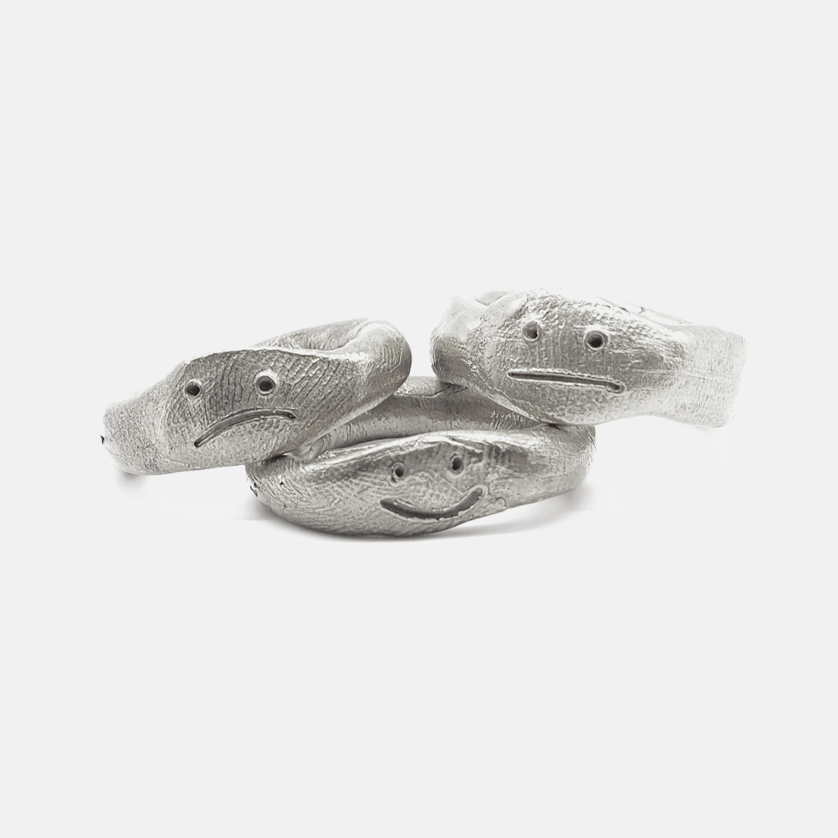 Three silver fish-shaped rings on a white background
