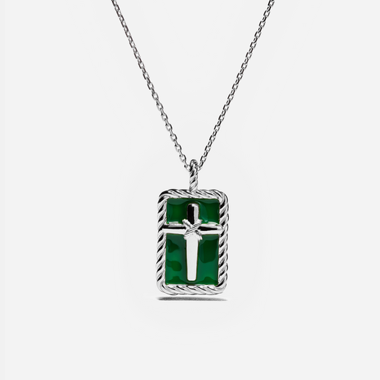 A silver chain necklace with a rectangular pendant featuring a green inlay and a silver cross in the center, set against a light gray background.