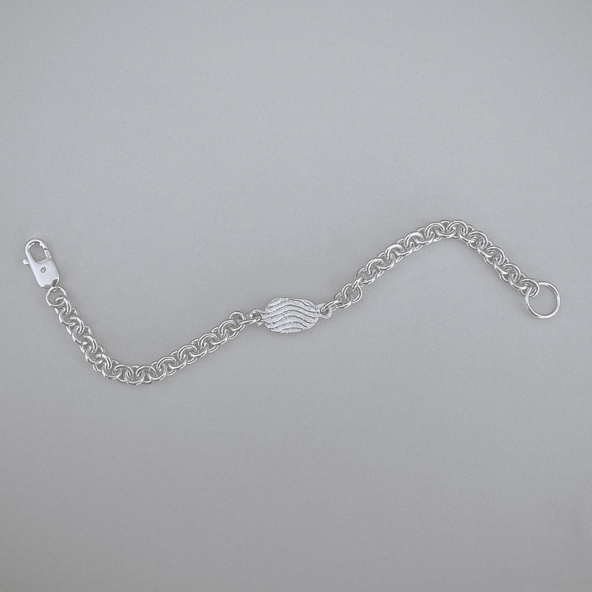 Silver chain bracelet on a gray background