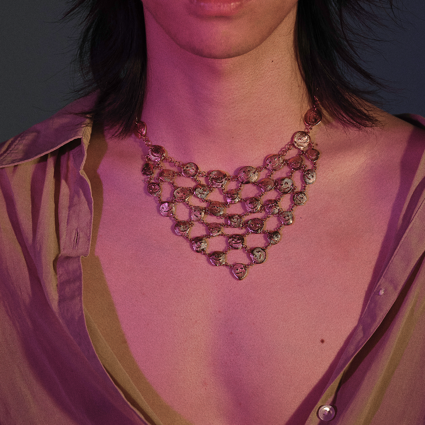 Contemporary gold sculptural necklace styled for evening wear