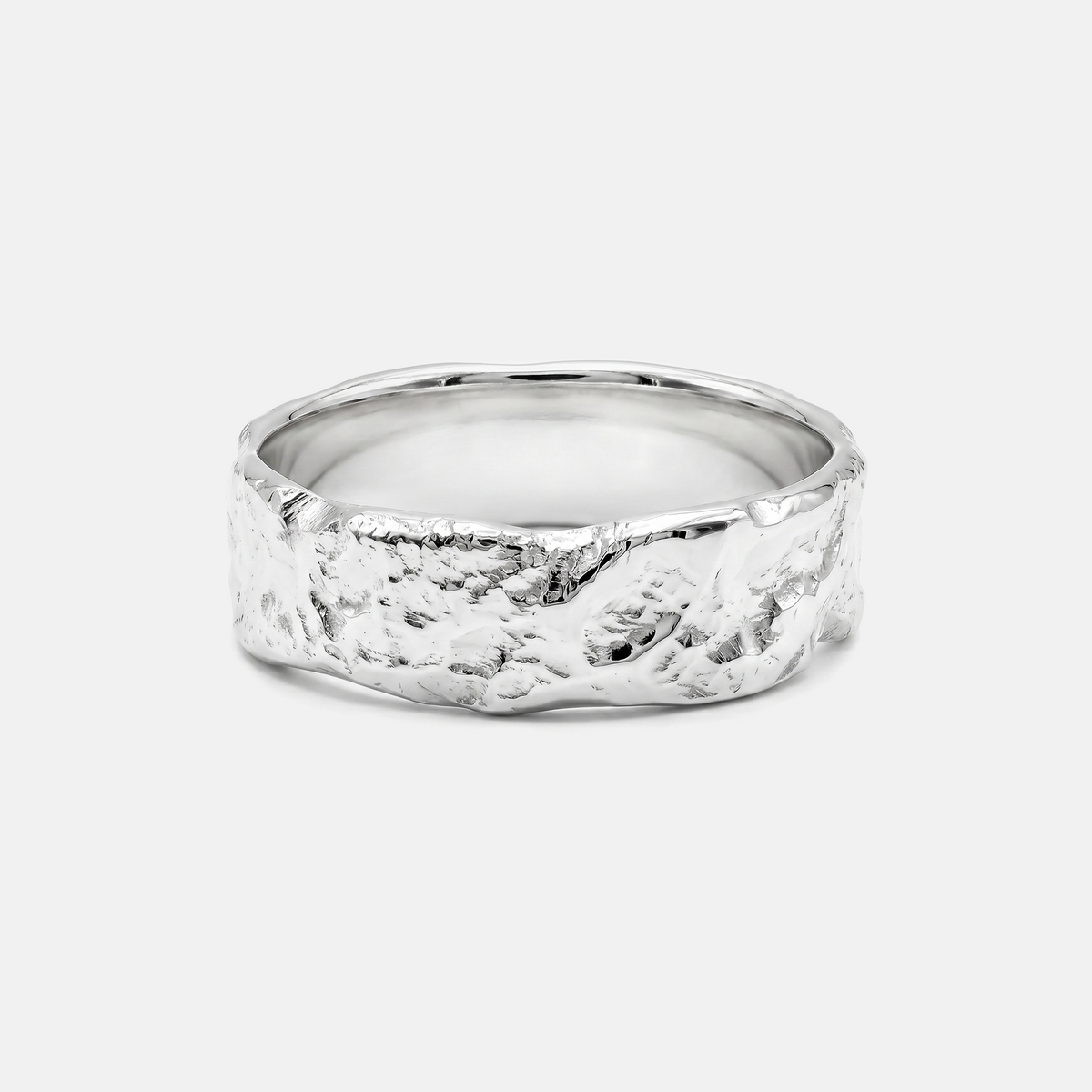 Silver ring with a textured band on a light gray background