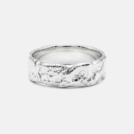 Silver ring with a textured band on a light gray background