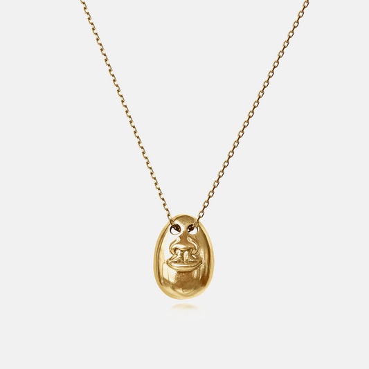 See No Evil Pendant Necklace in gold featuring a sculptural face motif on a delicate chain against a white background.
