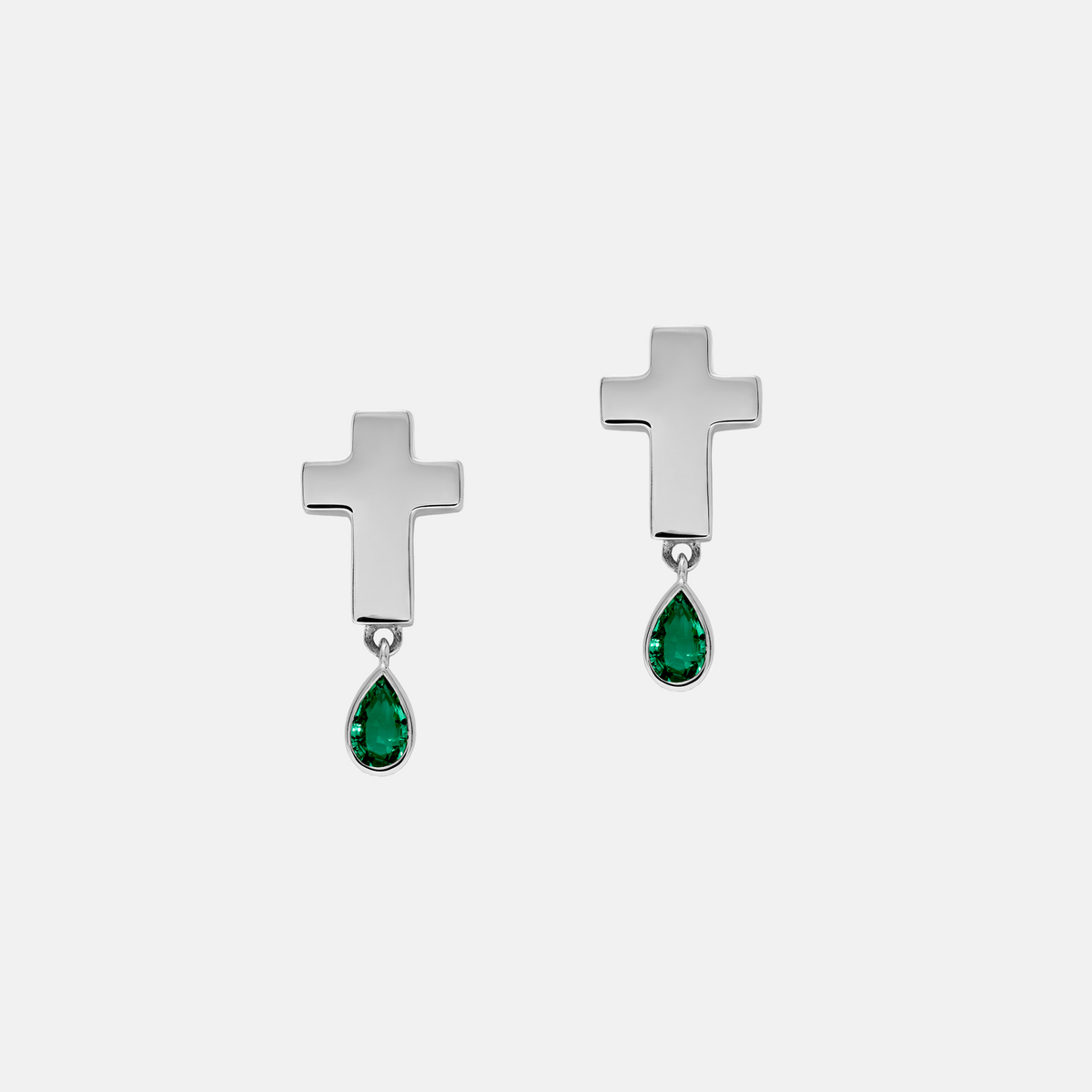 A pair of silver cross dangle earrings with teardrop-shaped green gemstones, shown on a light gray background.