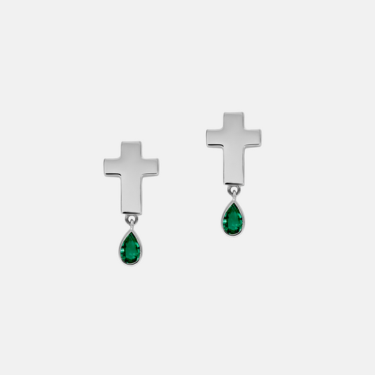 A pair of silver cross dangle earrings with teardrop-shaped green gemstones, shown on a light gray background.