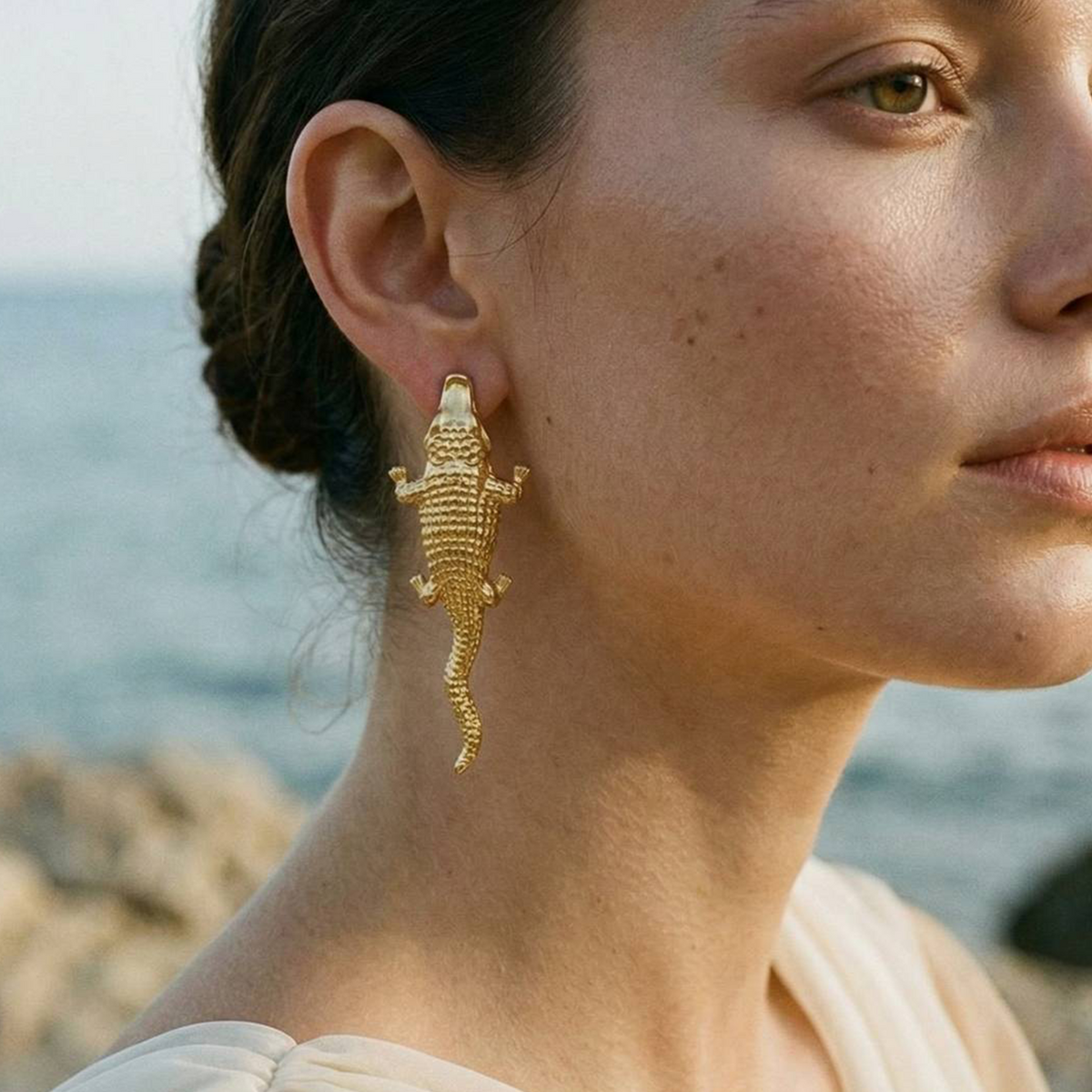 Model wearing crocodile-inspired statement earrings