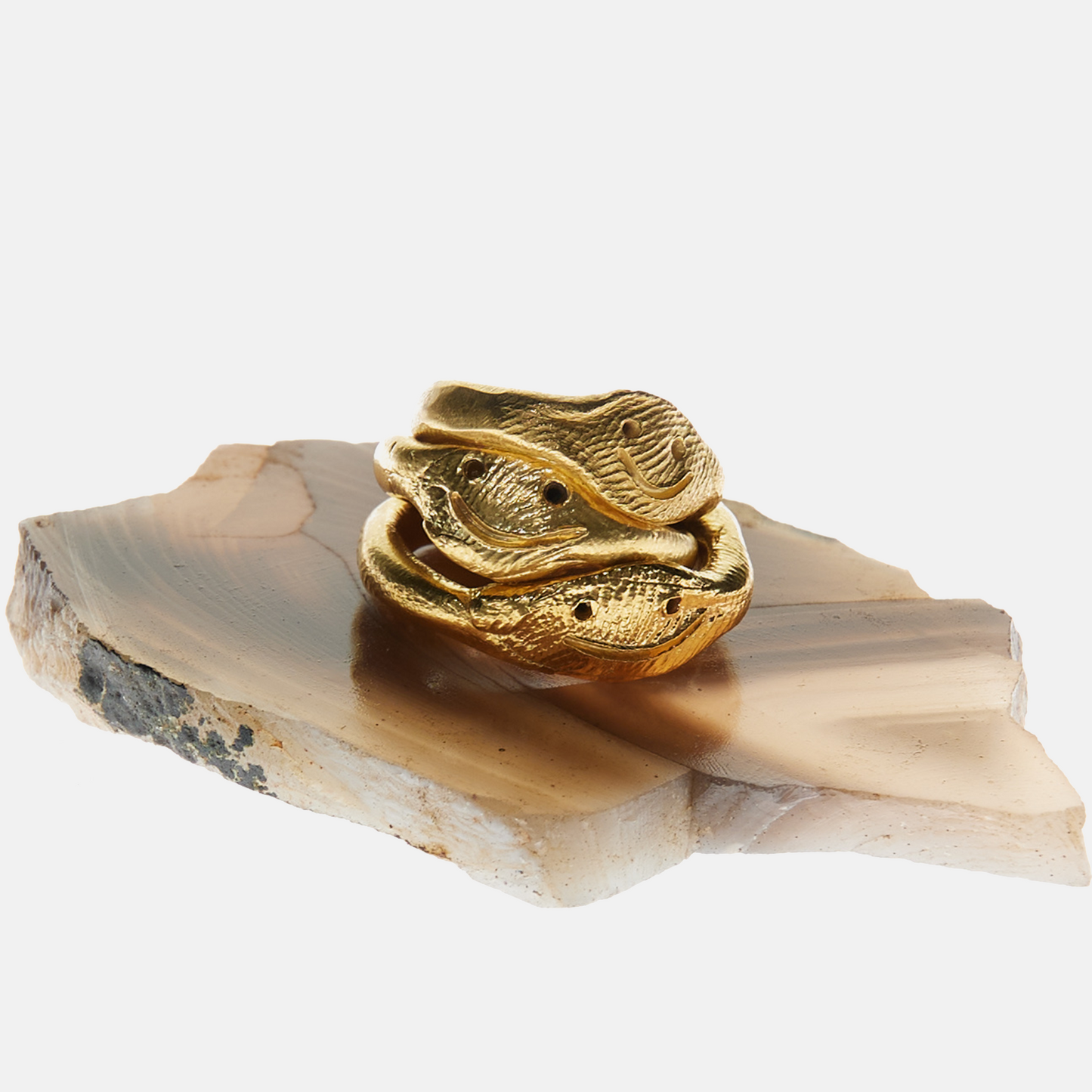 Gold decorative item on a stone surface with a white background