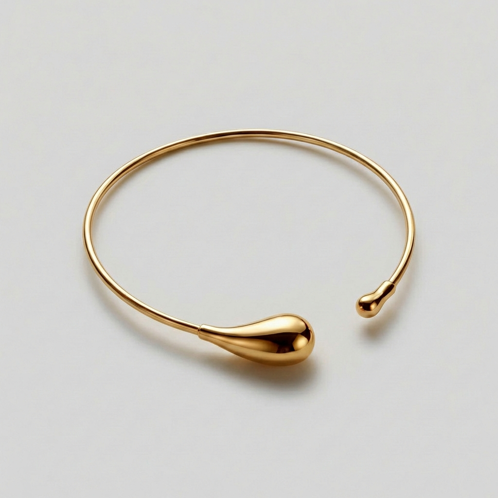 Gold bracelet on a light gray background