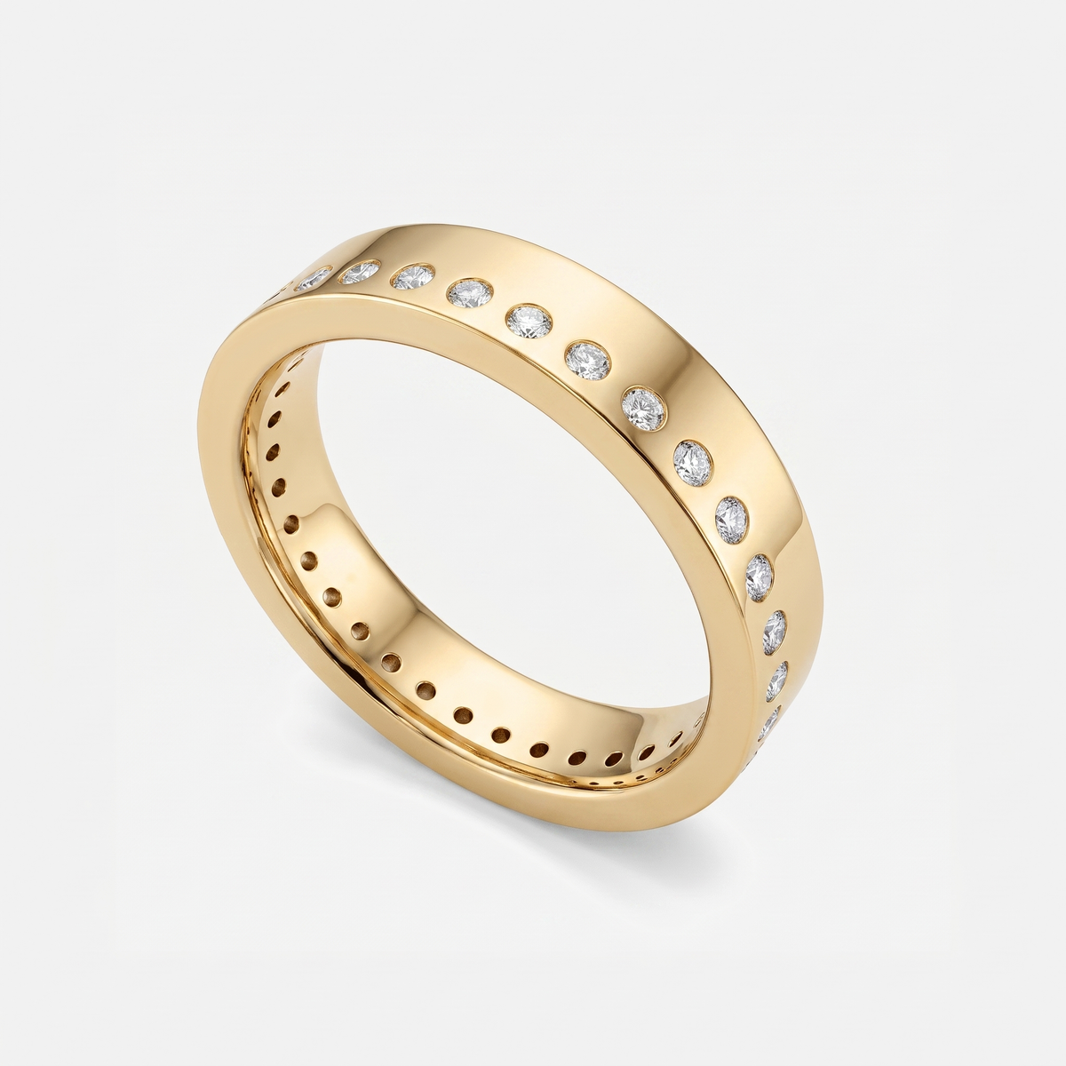 A polished yellow gold eternity-style ring with a row of small clear gemstones set around the outer band, shown on a clean light gray background.